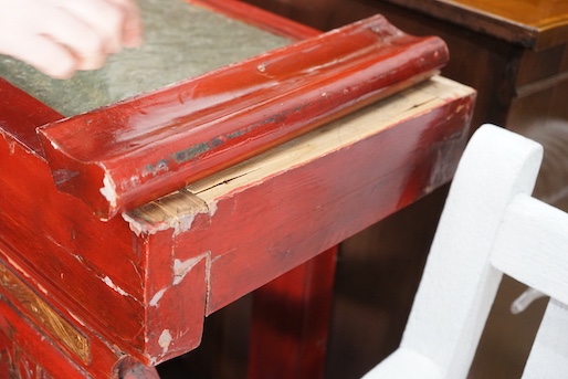 A Chinese carved scarlet and gilt painted altar table with faux stone top, length 198cm, depth 41cm, height 98cm